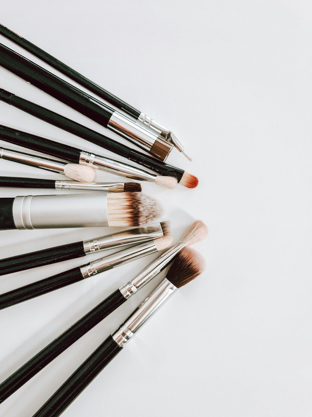 Professional brow spoolies and styling brushes arranged on a salon workstation