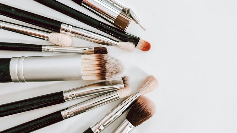 Professional brow spoolies and styling brushes arranged on a salon workstation