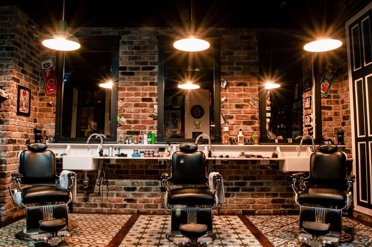 Vintage leather barber chairs lined up inside an empty barber shop