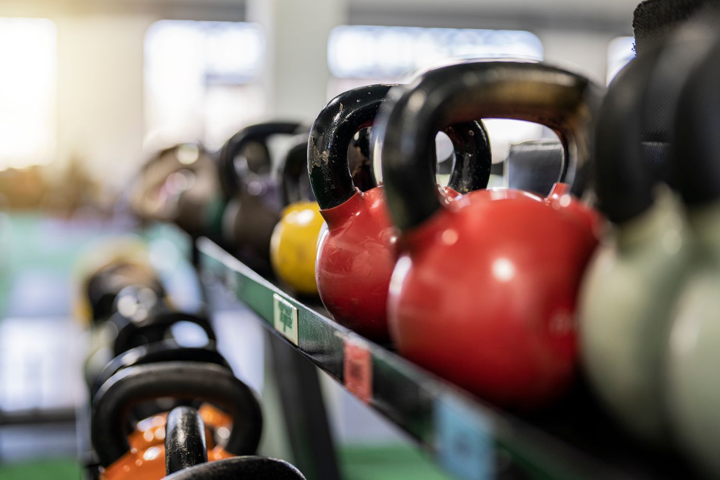 Kettlebells lined up on a rack in a gym