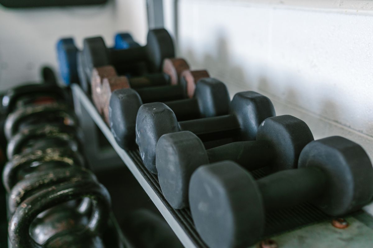 Rack of black neoprene dumbbells in a working gym