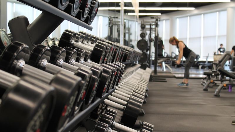 Modern gym training floor with dumbbell racks and workout equipment