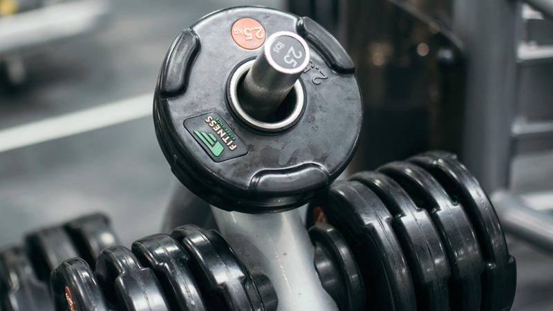 Row of heavy dumbbells on a gym rack in a fitness studio