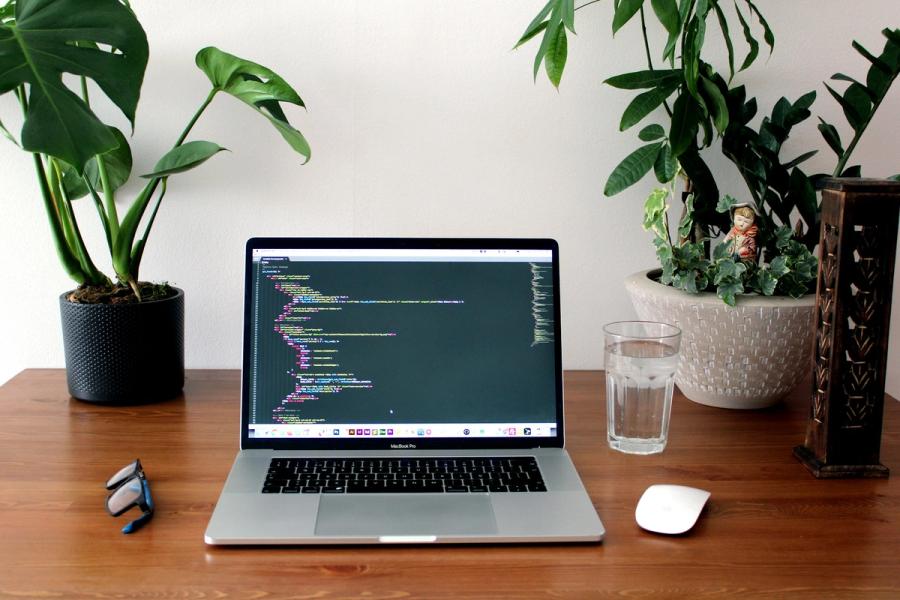 Laptop showing code on a developer workspace desk