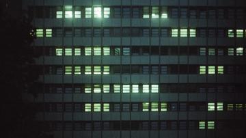 Gebäude in der Nacht mit einigen beleuchteten Fenstern.