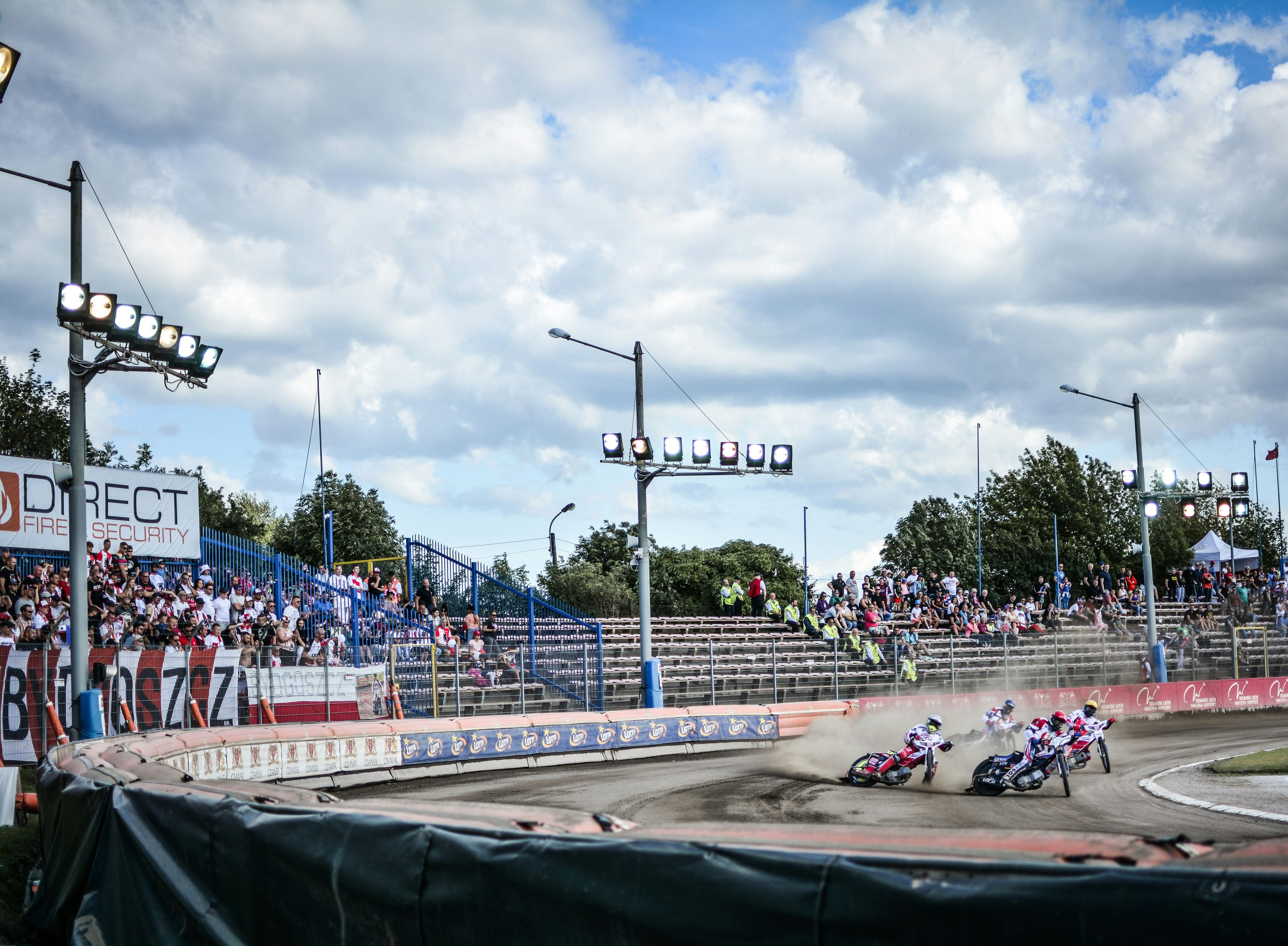 a group of people riding motorcycles around a track