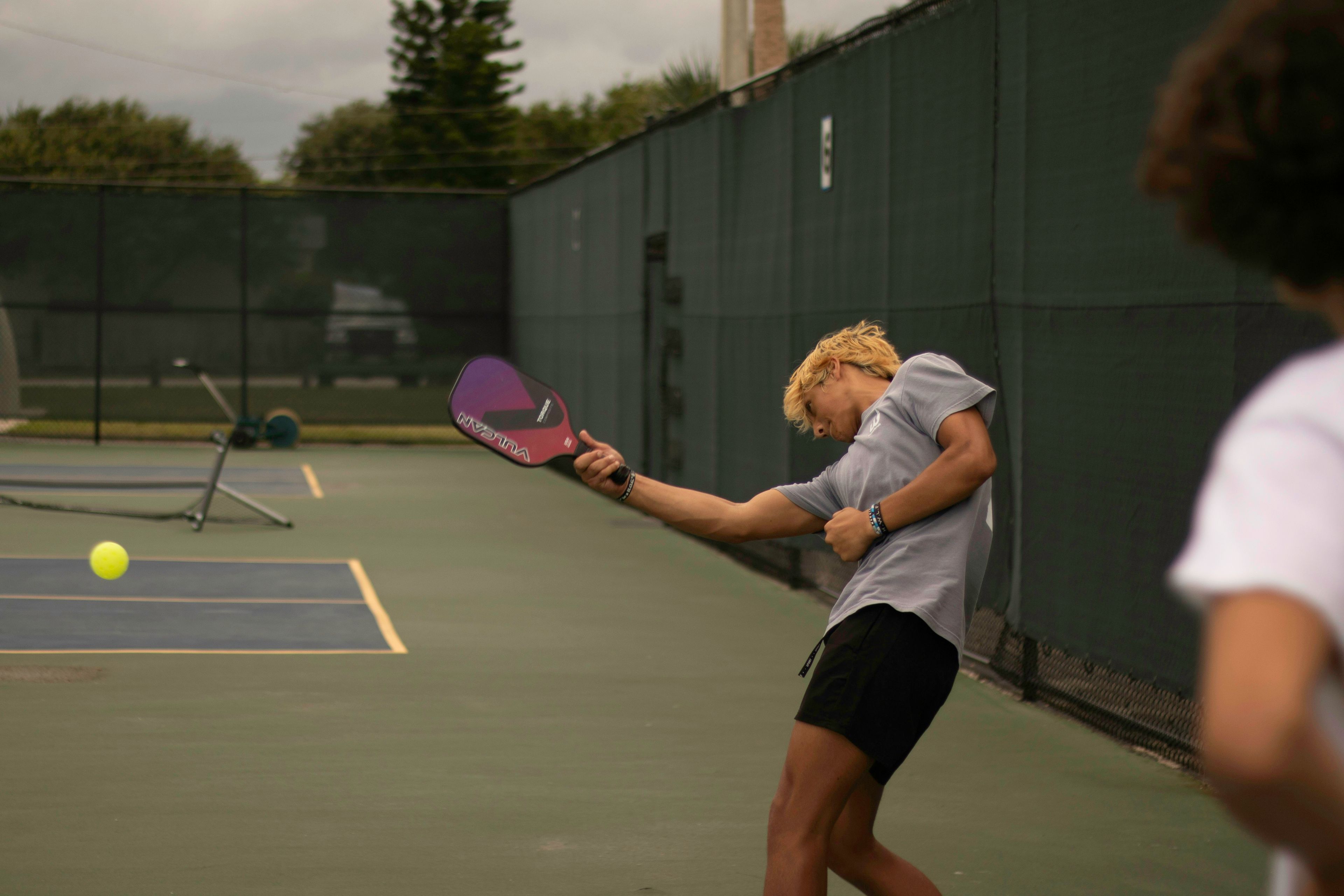 A woman hitting a tennis ball with a racquet