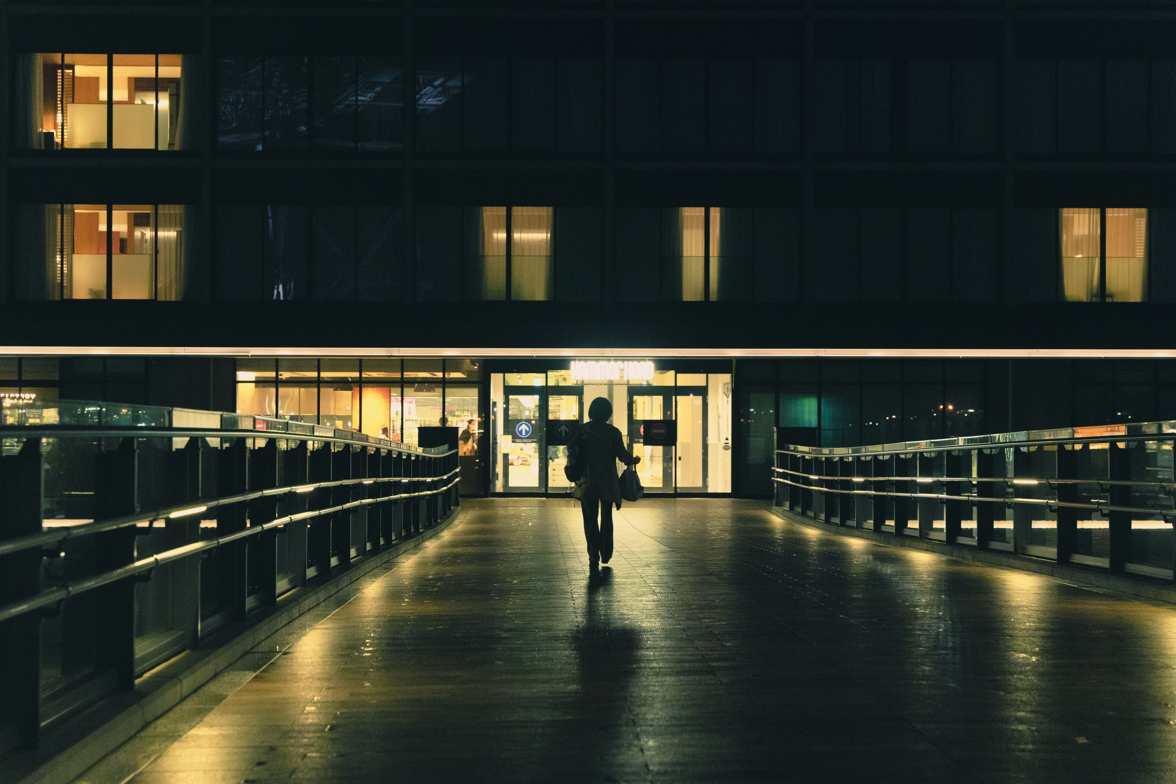 a person walking down a walkway at night