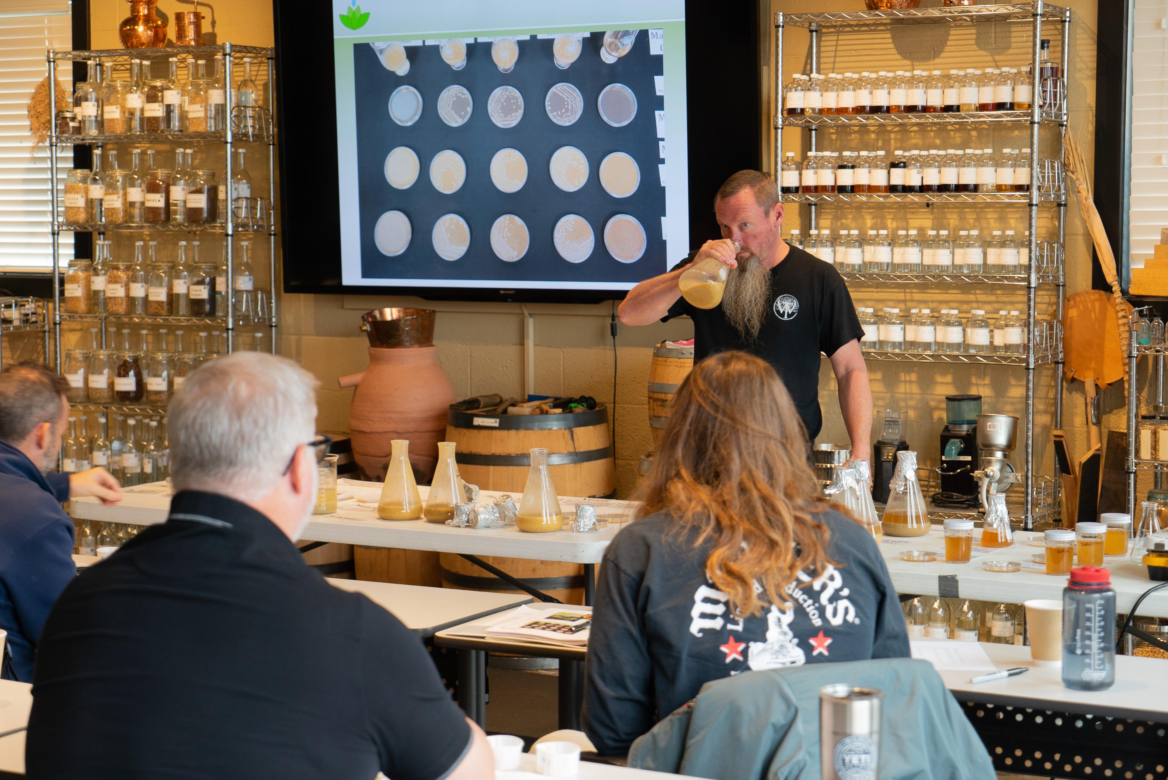 Pat smelling flask of mash