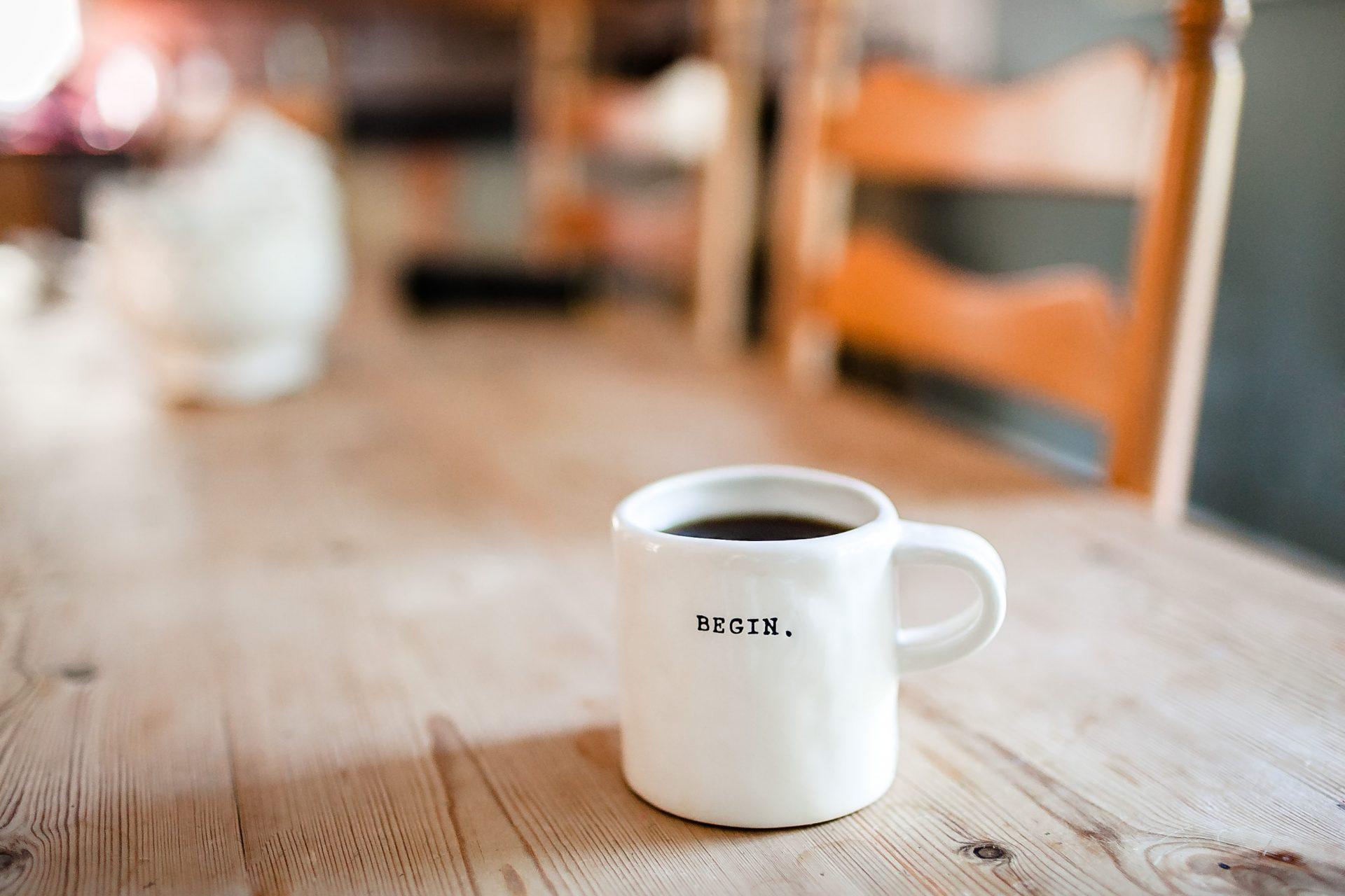coffee in mug that says "Begin"