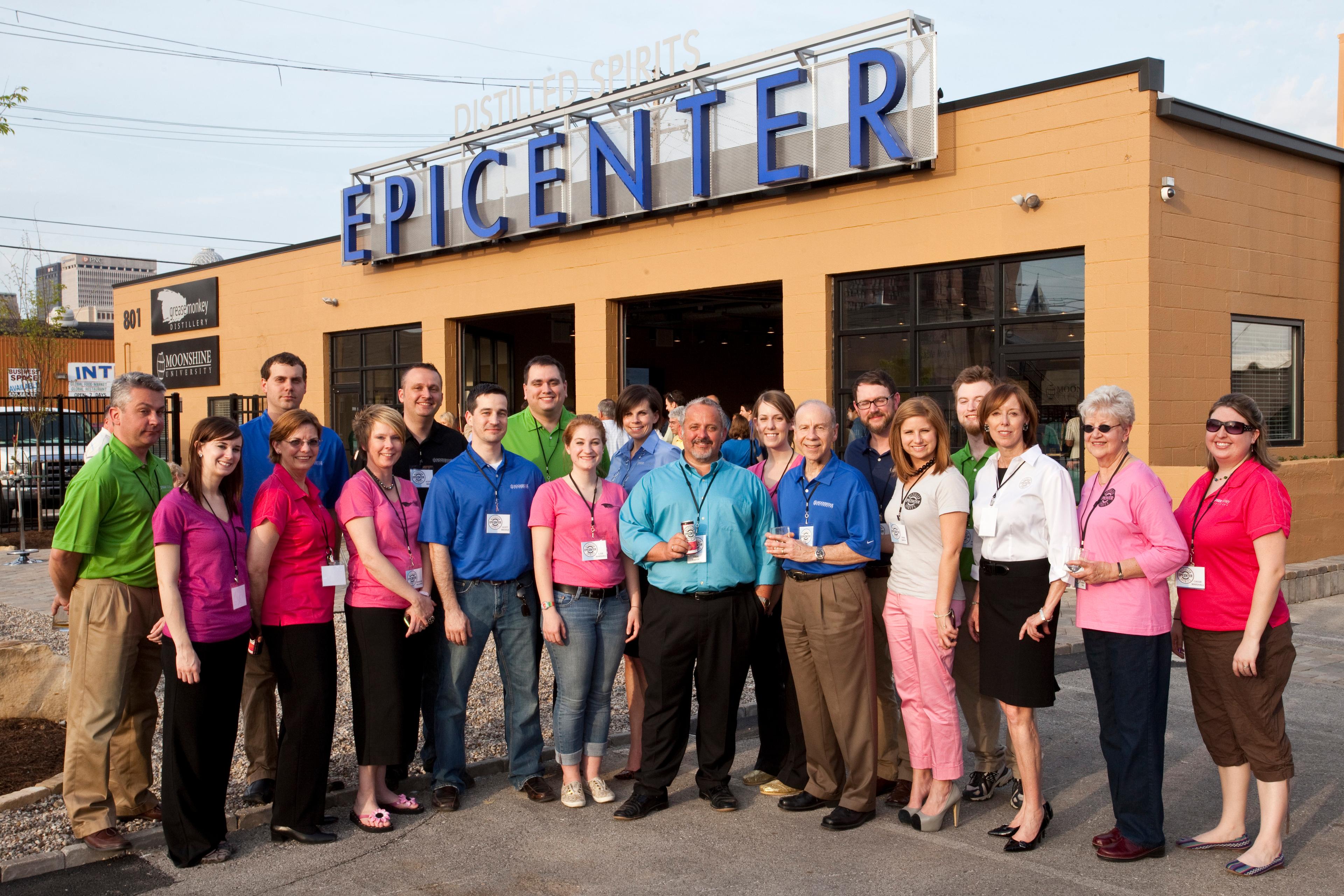 Team members pose for photo in front of the newly opened building.