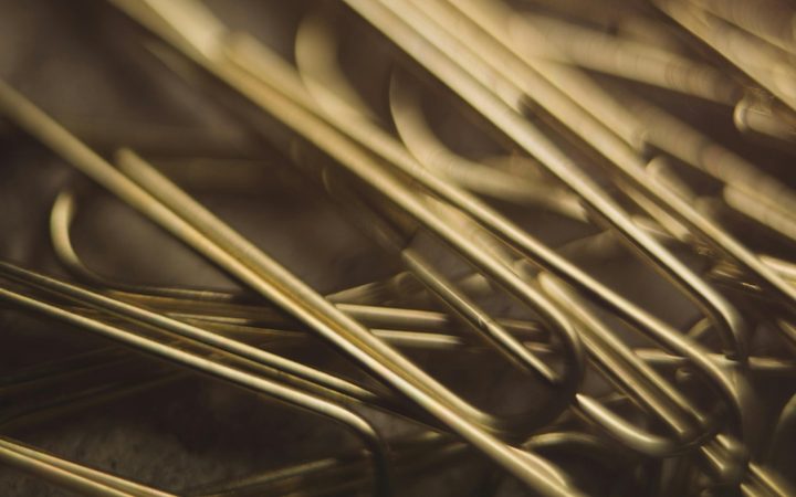a close up of gold paper clips