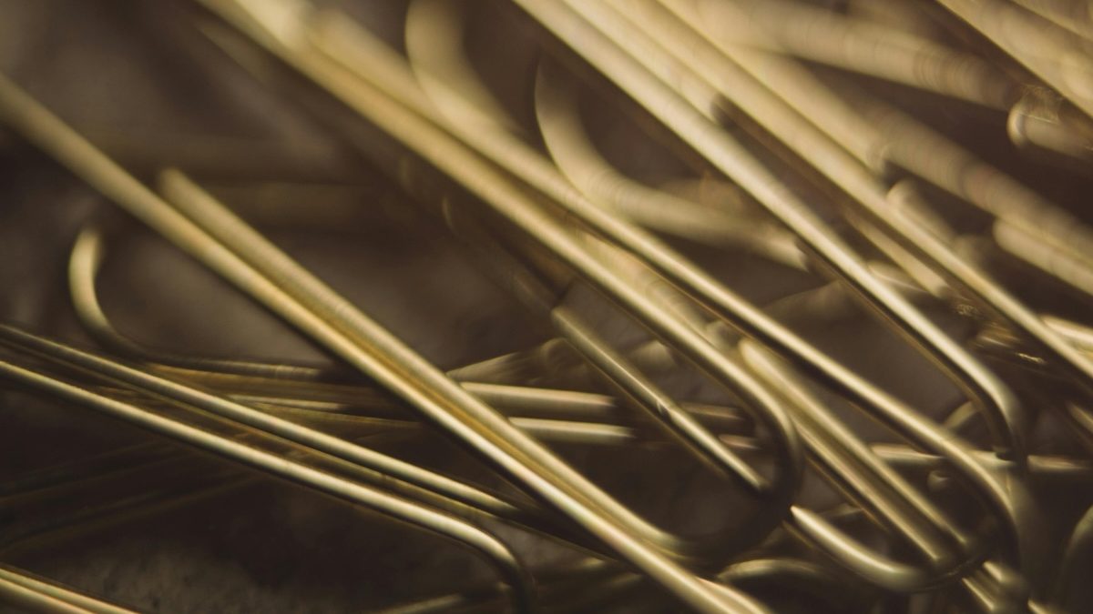 a close up of gold paper clips