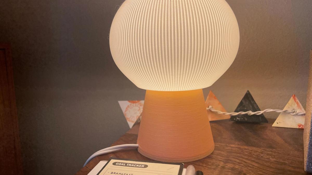 A small, soft lamp with a peach base and yellow, spherical pleated shade.