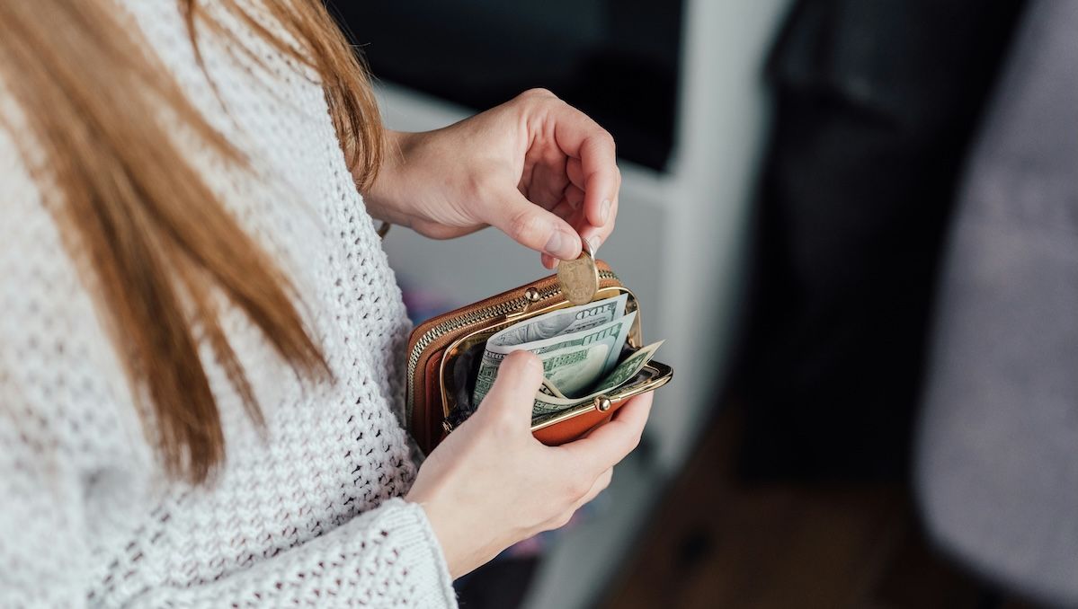 A woman putting money into her wallet
