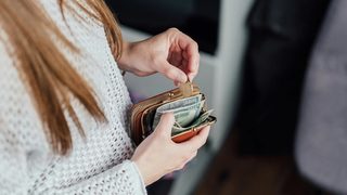A woman putting money into her wallet
