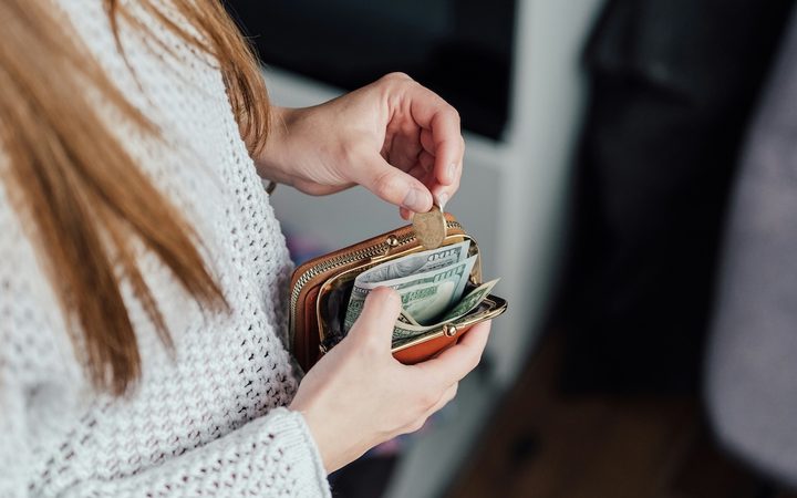 A woman putting money into her wallet