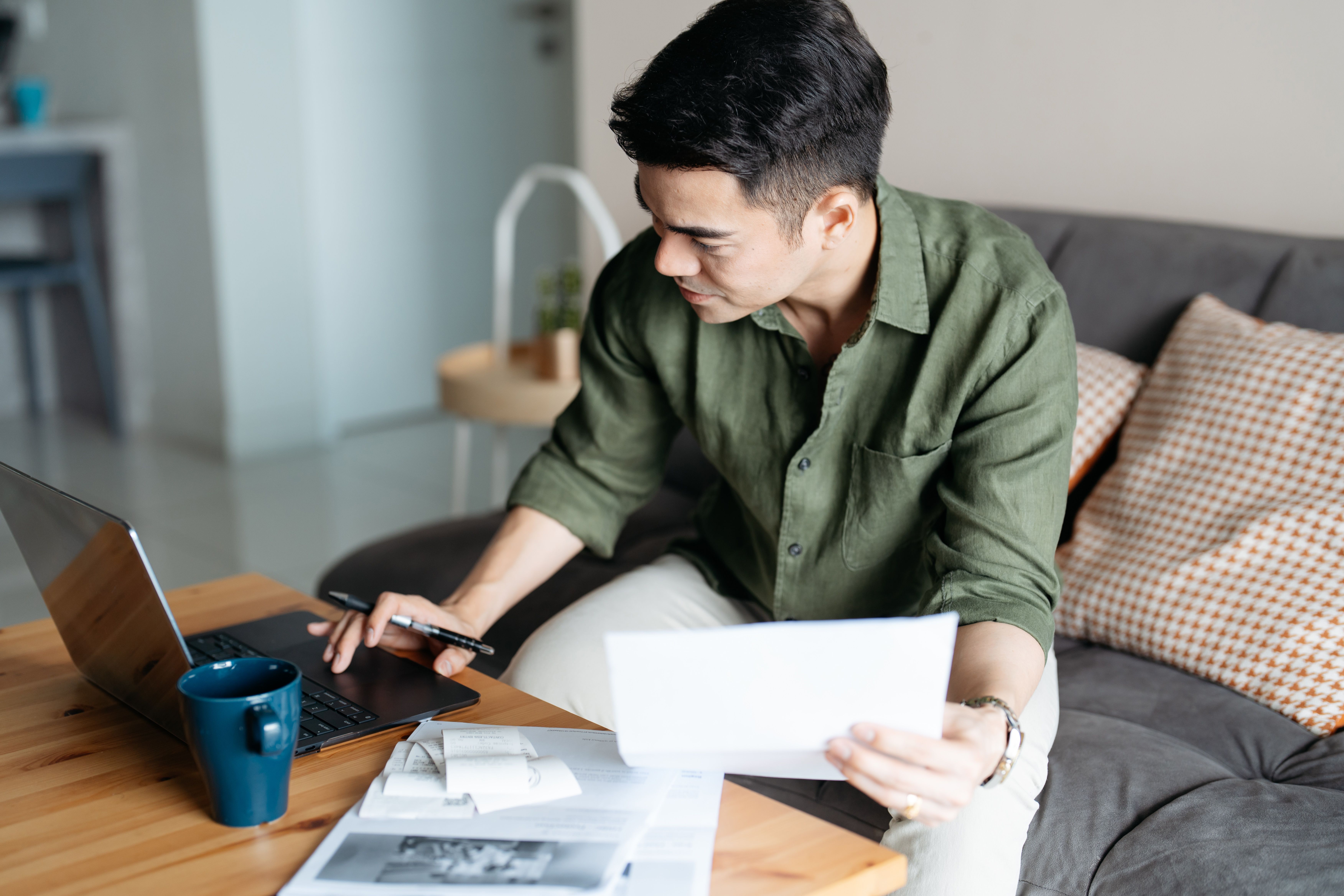 Man sitting at a desk with a laptop and paperwork.