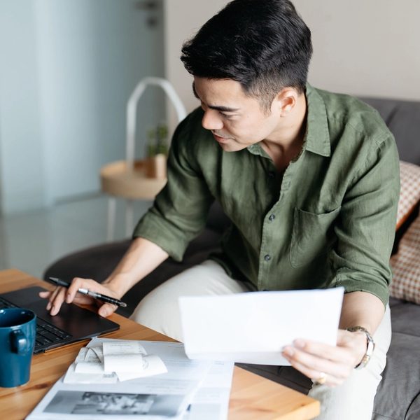 Man sitting at a desk with a laptop and paperwork.