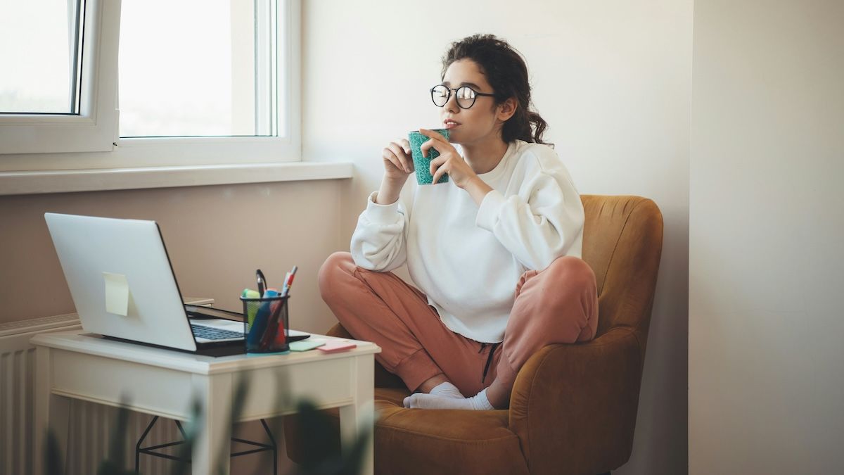 a woman with bipolar disorder sits in her home office drinking coffee