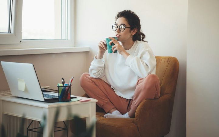 a woman with bipolar disorder sits in her home office drinking coffee