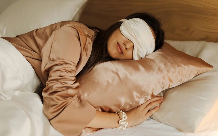 Woman sleeping in bed with an eye mask on