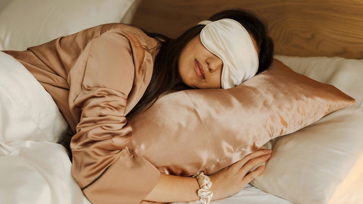 Woman sleeping in bed with an eye mask on