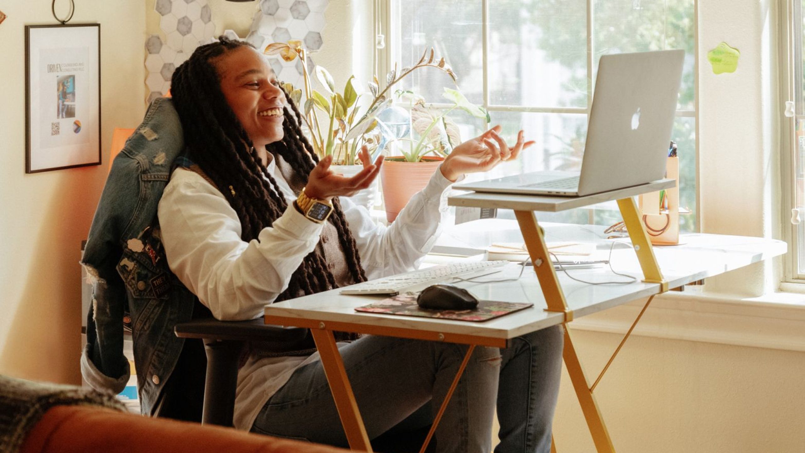 Alma therapist looking at a laptop and smiling while making an explanatory gesture with hands