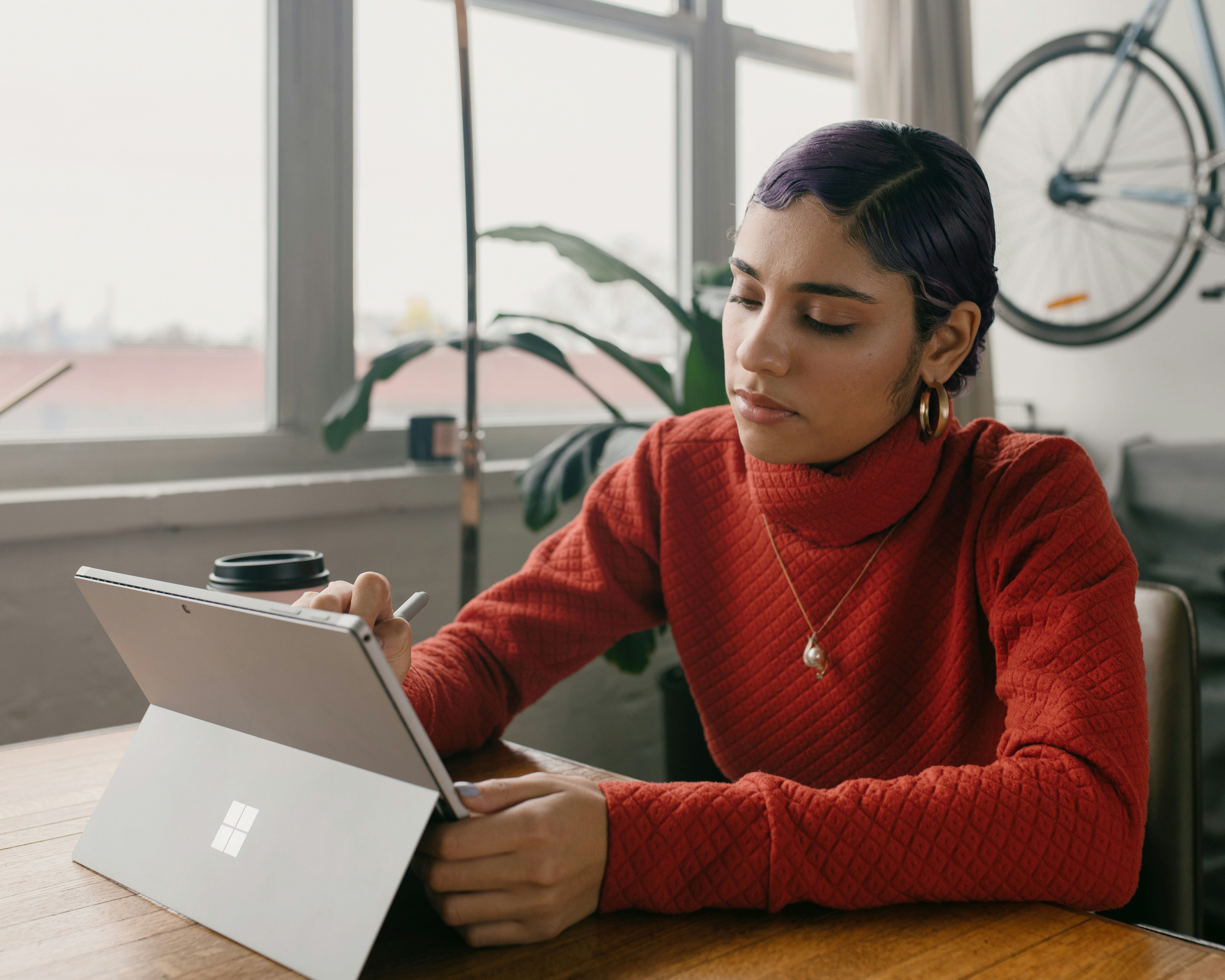 Person in red sweater using Surface