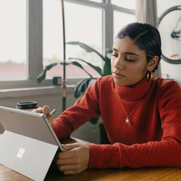 Person in red sweater using Surface