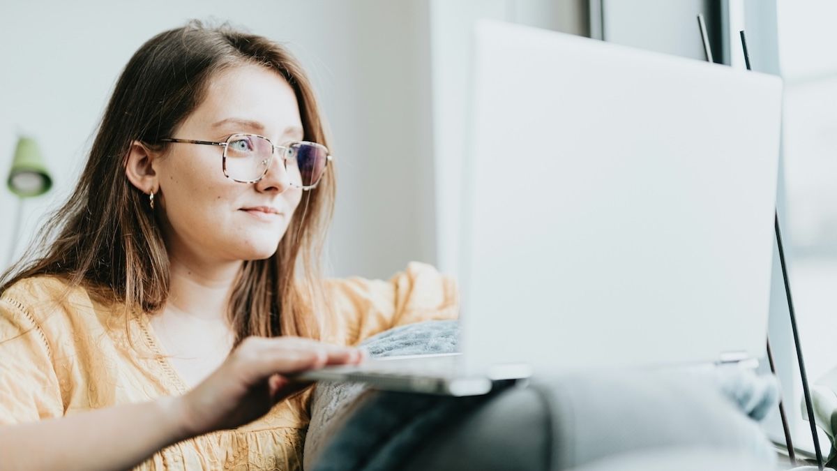 a hopeful young woman looks into her laptop screen