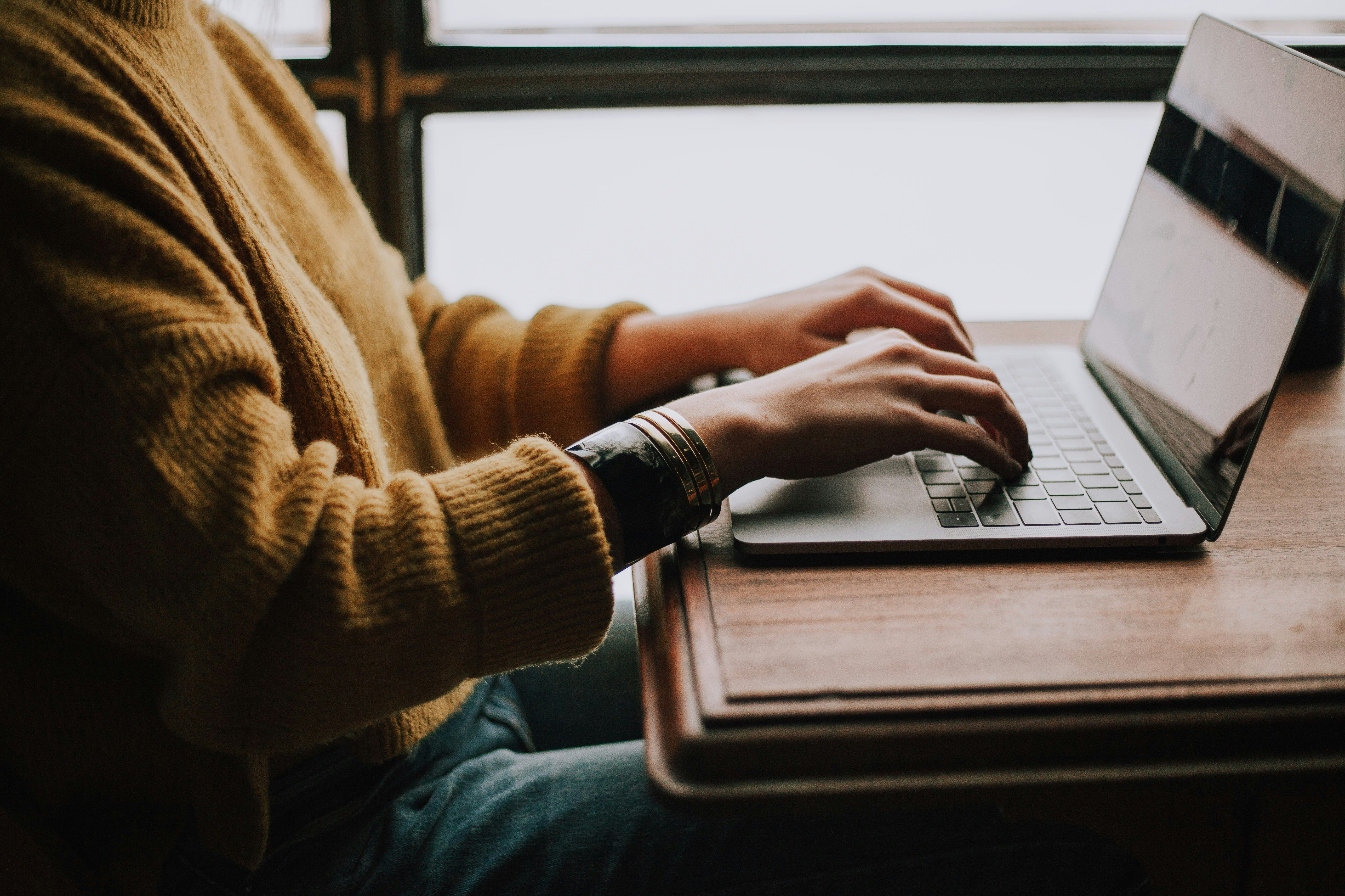 Person seated at table with laptop