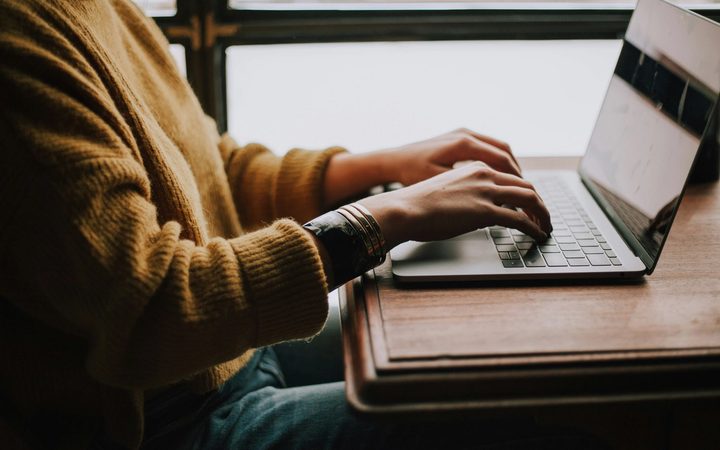 Person seated at table with laptop