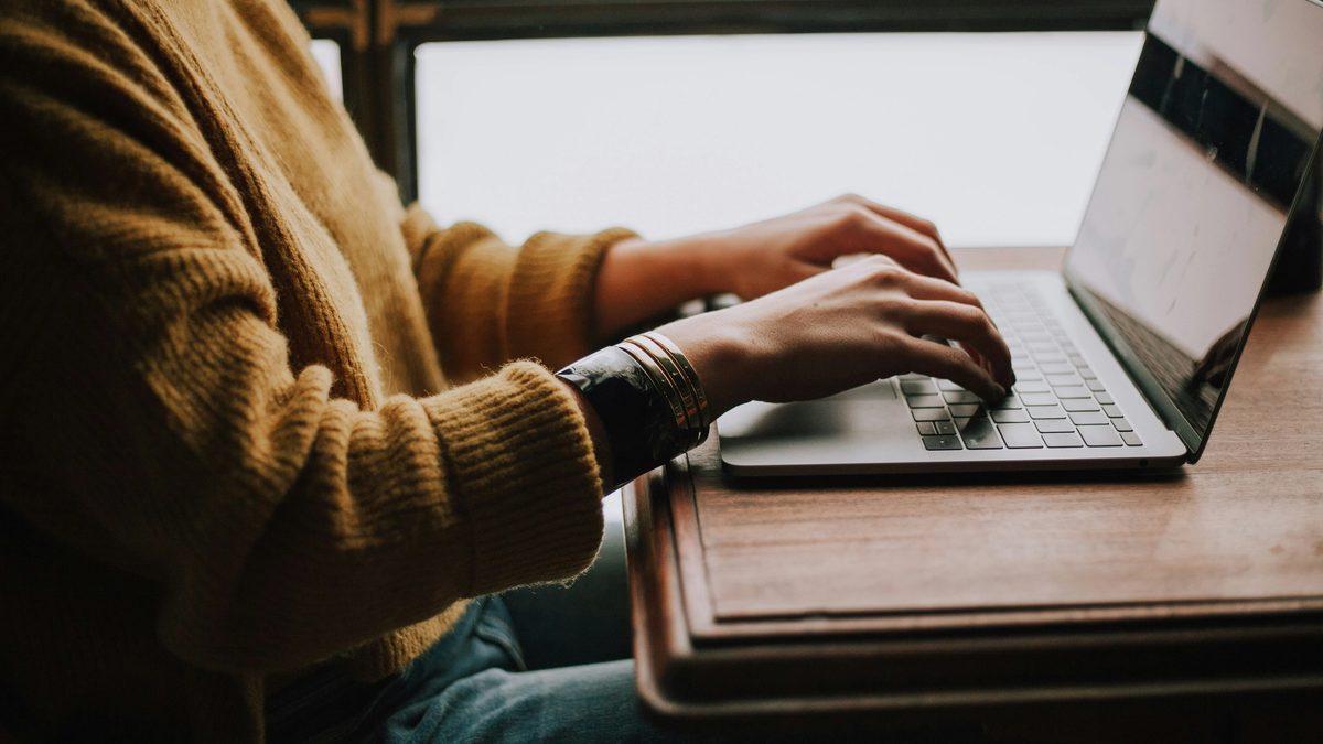 Person seated at table with laptop