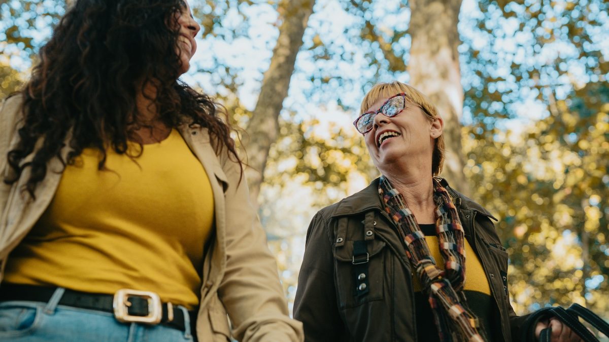 a young woman and her older female therapist doing conducting a therapy session as they walk outside on an autumn day