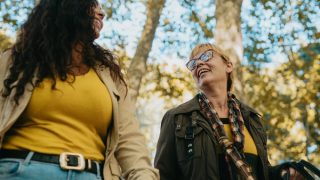 a young woman and her older female therapist doing conducting a therapy session as they walk outside on an autumn day