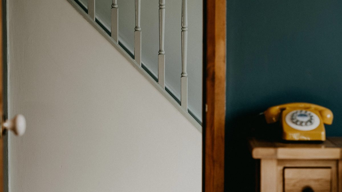A fleeting glance from within a quiet therapy office, looking through an open door into an empty hallway.