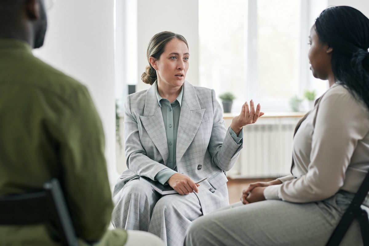 A therapist sits across from two clients