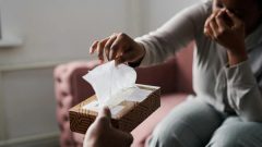 a crying woman reaches for tissue in a therapy session