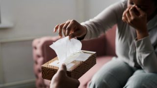 a crying woman reaches for tissue in a therapy session