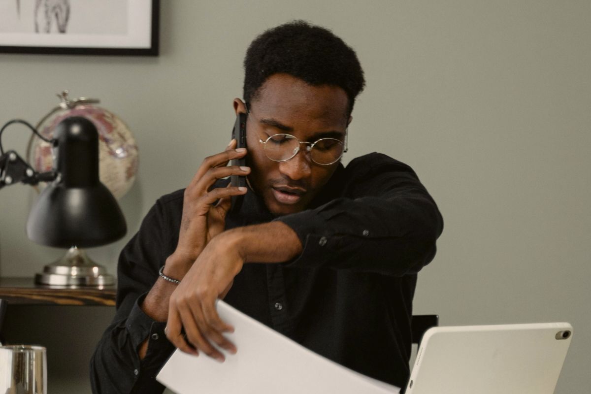 A mental health therapist doing admin work in their office, on the phone with an insurance provider