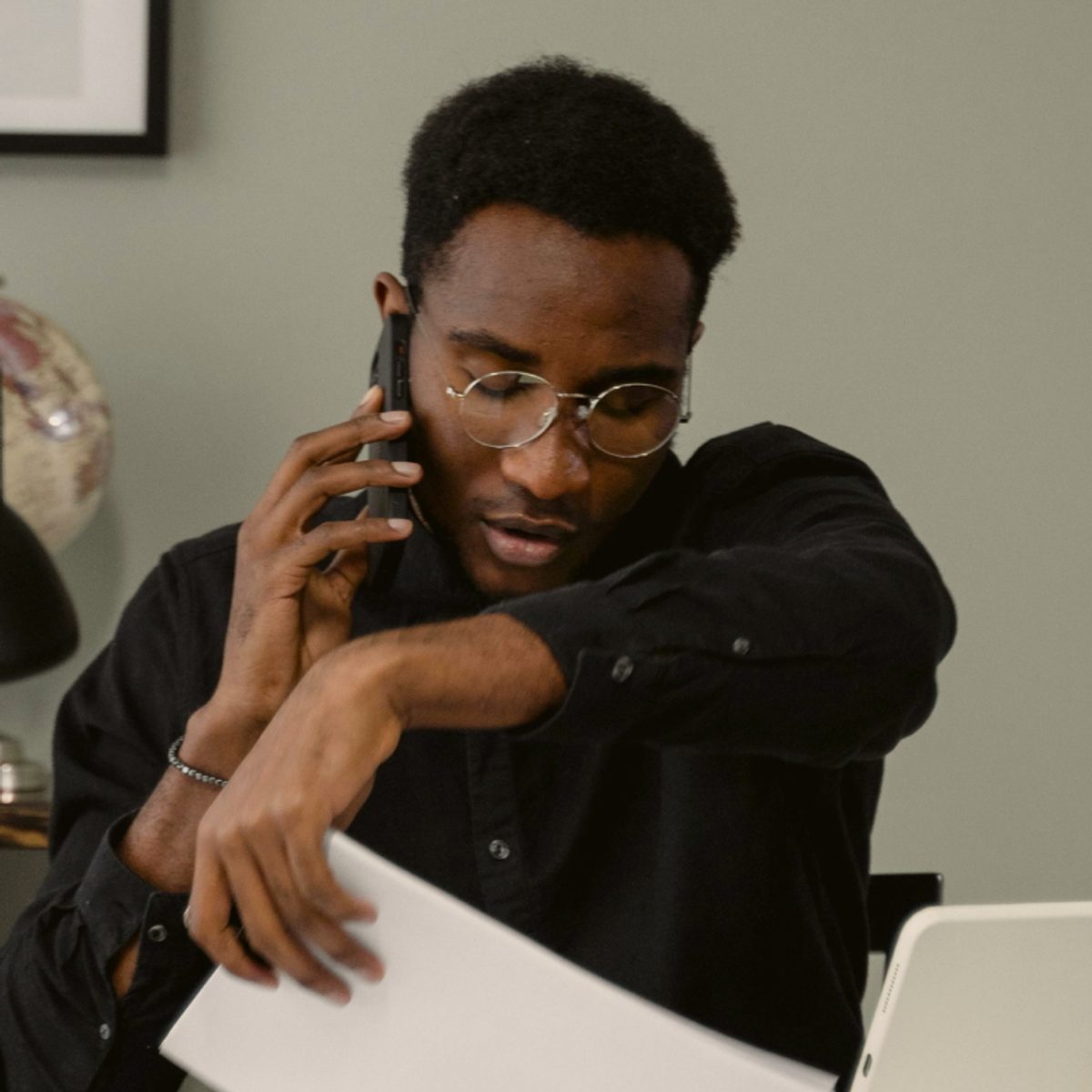 A mental health therapist doing admin work in their office, on the phone with an insurance provider