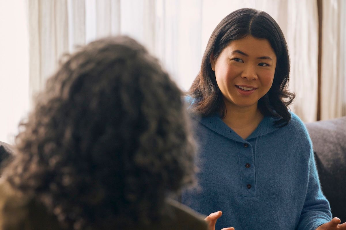 an Asian American woman smiles in a therapy session