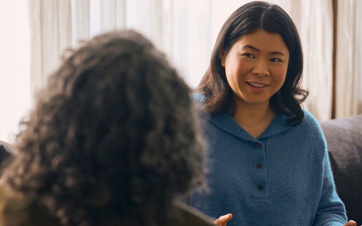 an Asian American woman smiles in a therapy session