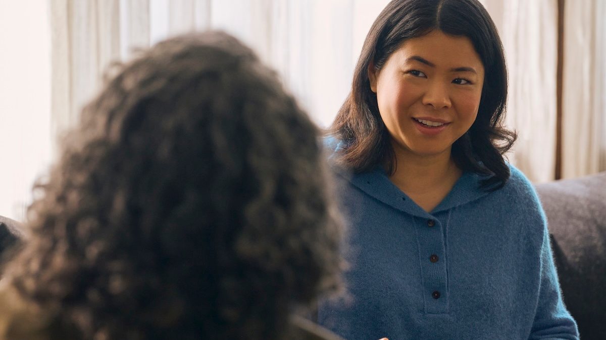 an Asian American woman smiles in a therapy session