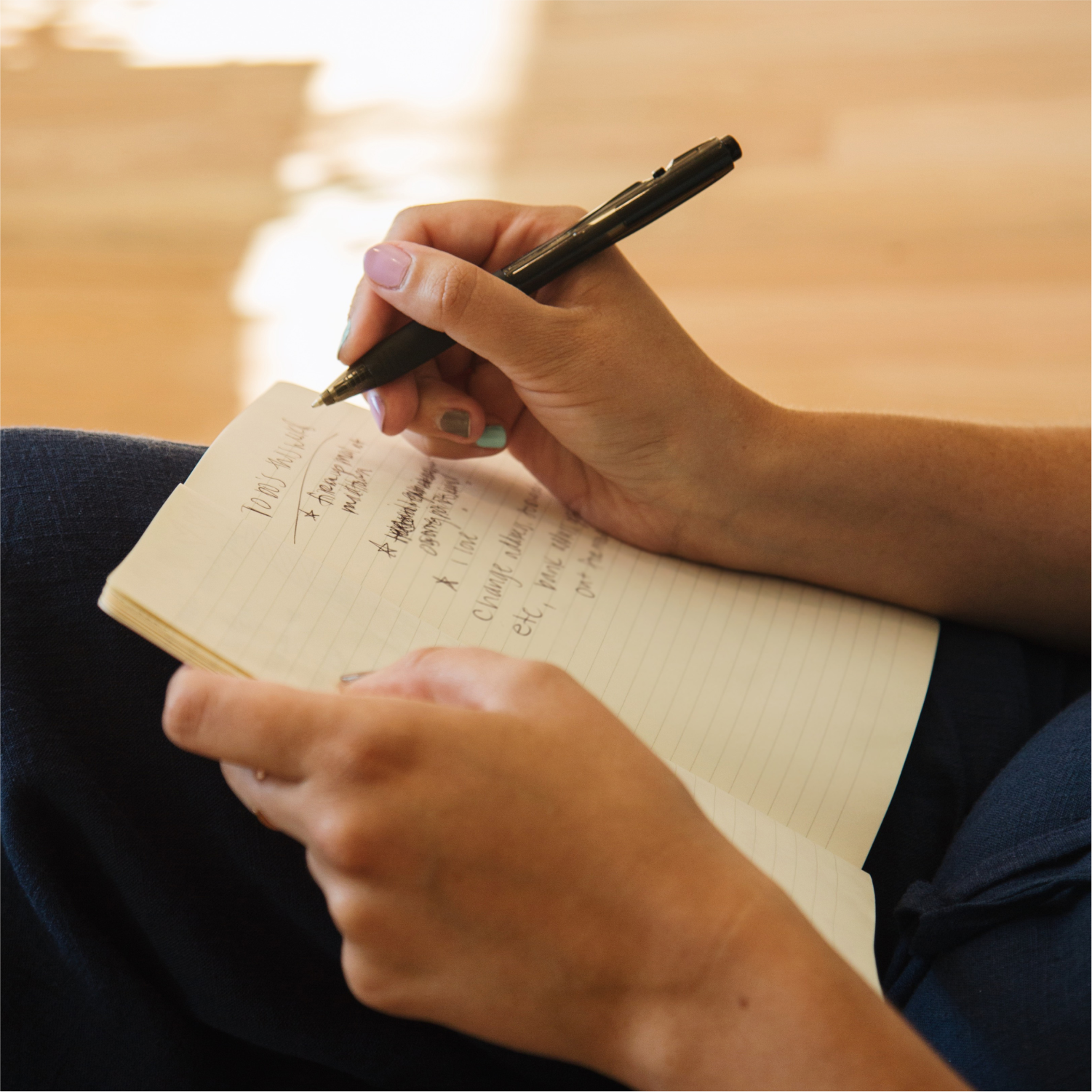 Close up on hands writing in a notebook