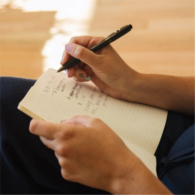 Close up on hands writing in a notebook