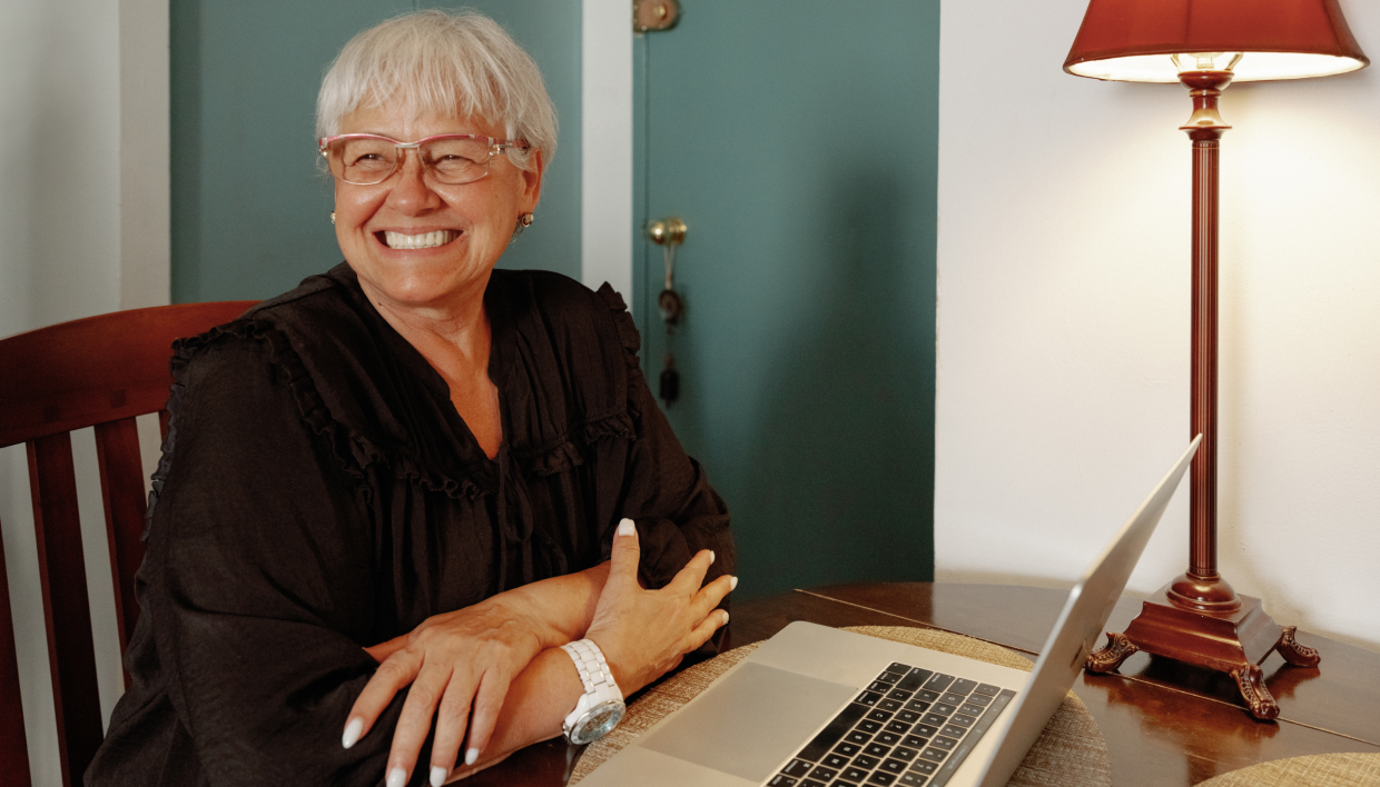 Alma provider smiling while sitting in front of laptop