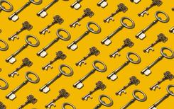 Many ornate brass keys laid flat in a perfectly repeating pattern on a marigold backdrop.