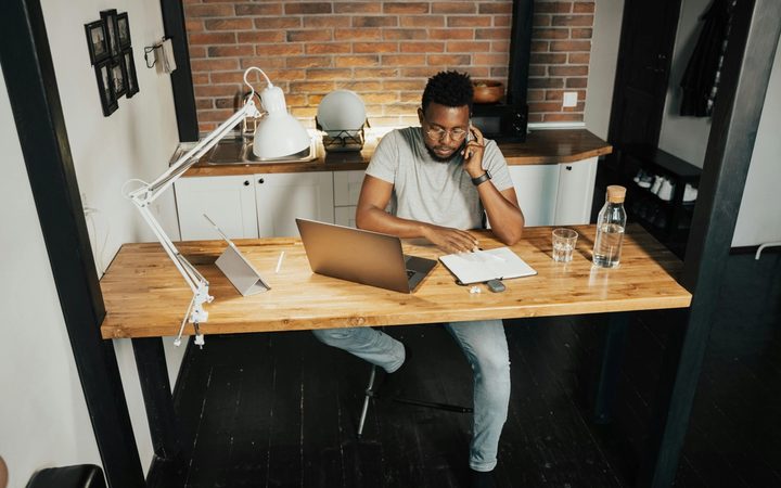 Person sitting at a desk while on the phone and looking at notes